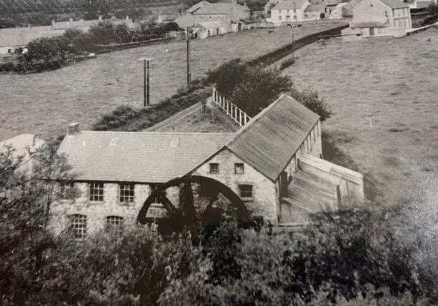 Black and white photograph of Elvet Woollen Mill with its original water wheel